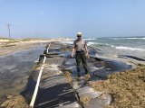 Superintendent David Hallac standing on a damaged stretch of NC-12 on Ocracoke Island.